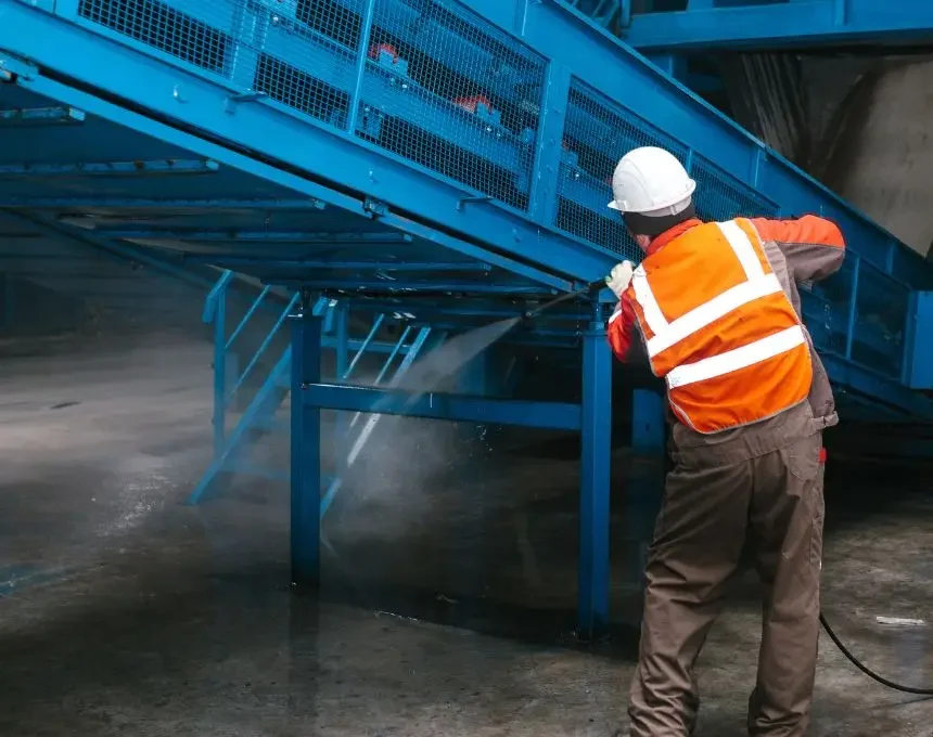 Worker washes equipment at the waste sorting plant